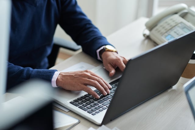 high-angle-view-cropped-employee-work-with-laptop